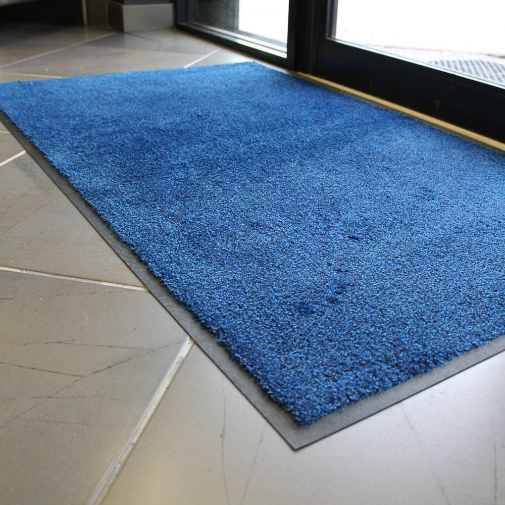 Photo-of-a-blue-COBAwash-mat-on- the-inside-of-a-doorway-placed-on- tiled-flooring