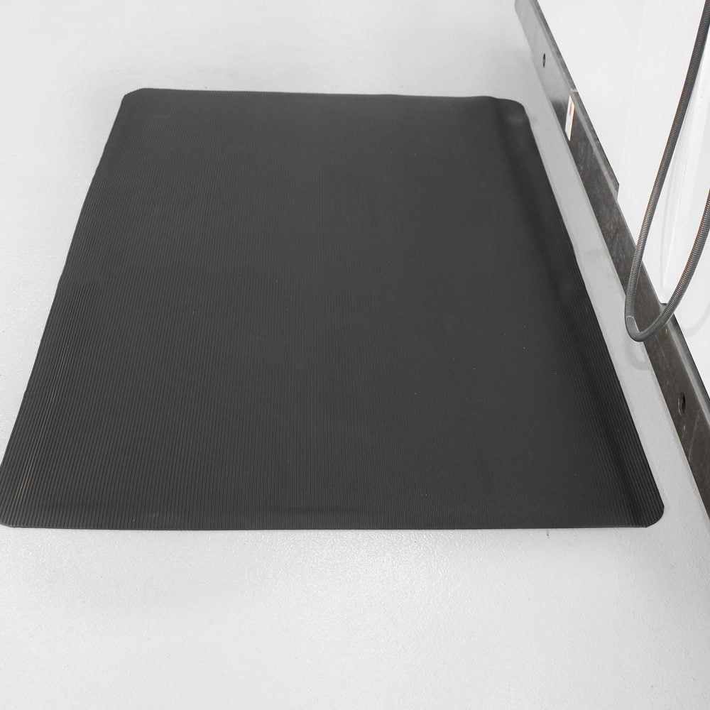 Isolated-image-of-a-black-fluted-anti- fatigue-mat-on-a-white-floor