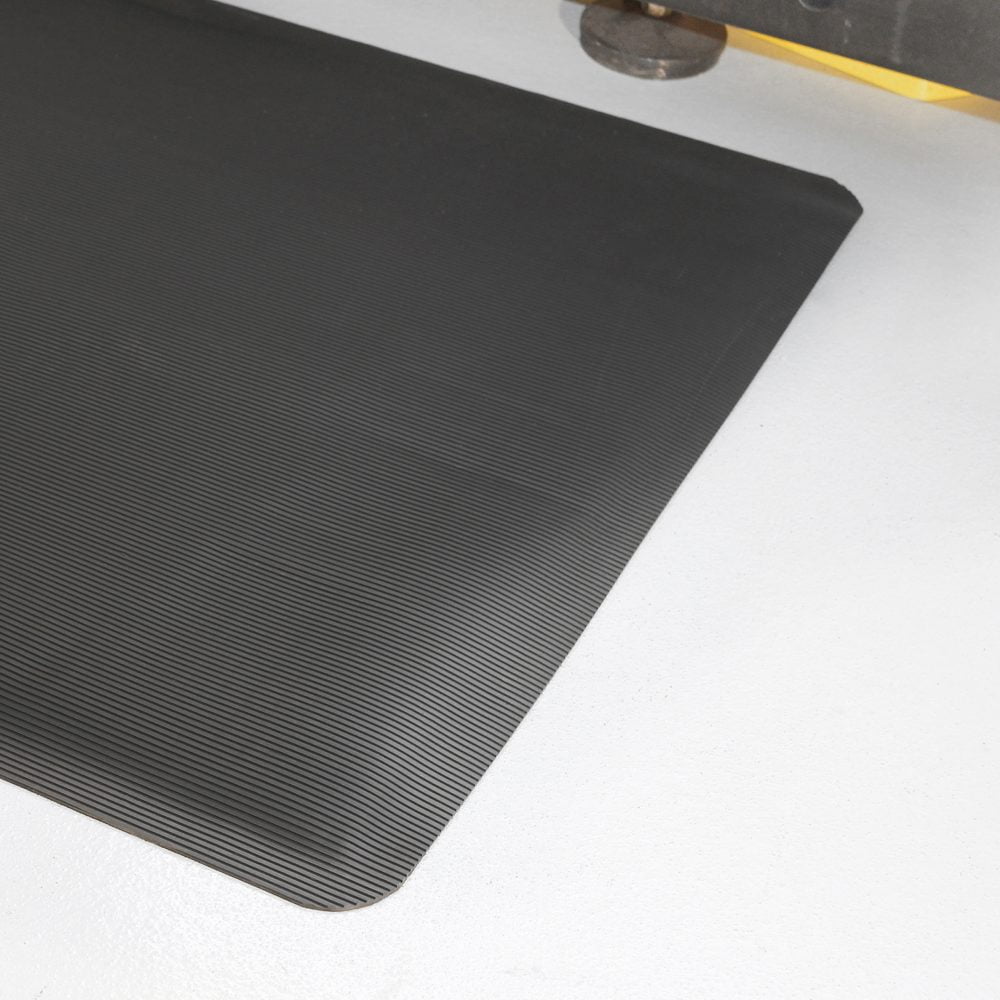 Corner/edge-shot-of-a-black-fluted- anti-fatigue-mat-on-a-white-floor