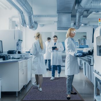 Image-of-multiple-workers-standing-a- grey-and-black-Loopermat-in-a-lab