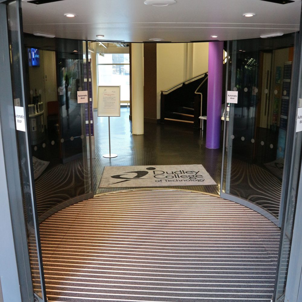 College-entranceway-with-revolving- doors-by-a-circled-Pathmaster-Alu- entrance-mat