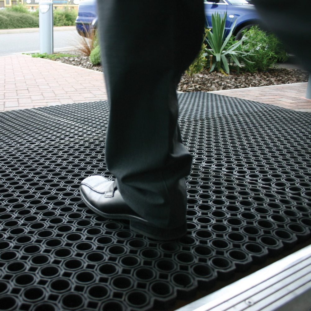 Person-stepping-outside-from-a-door- onto-a-black-rubber-Ringmat- Honeycomb