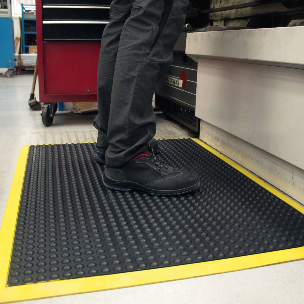 Worker-standing-on-a-black/yellow- Bubblemat-Safety-on-tiled-floor