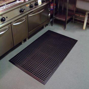 black-ramp mat-on-the-floor-beside-a-row-of-ovens